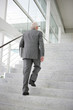 Grey-haired businessman climbing steps
