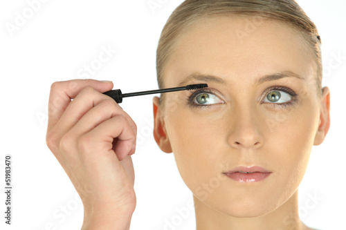 Photo: Blond applying mascara Blond applying mascara
