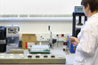 Woman in white clothing works in laboratory