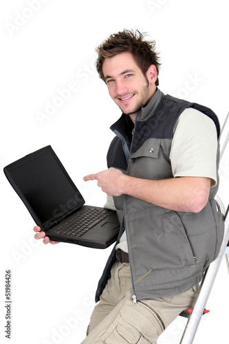 Photo: Tiler with a laptop showing a blank screen Tiler with a laptop showing a blank screen