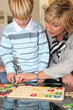 Grandmother helping her grandson with a puzzle