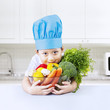 Foto: Boy chef holds bowl of vegetarian food Boy chef holds bowl of vegetarian food