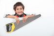 Little boy holding a saw on white background