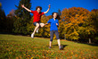 Girl and boy running, jumping in park