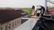 Alpinist Worker Preparing Safety Ropes on the Roof