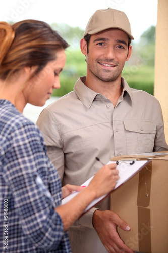 Photo: Woman signing for parcel Woman signing for parcel