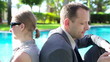 Video: Business couple with smartphone by the swimming pool Business couple with smartphone by the swimming pool