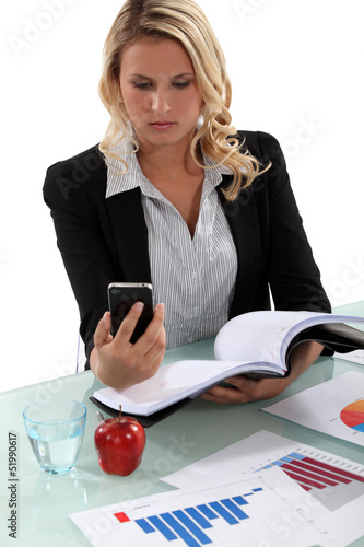 Photo: Blond woman reading through important documents Blond woman reading through important documents