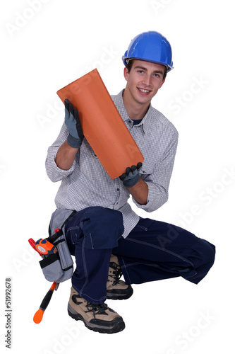 Photo: Craftsman crouching with tile Craftsman crouching with tile