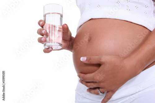 Photo: Pregnant woman holding a glass of water Pregnant woman holding a glass of water