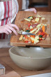 Photo: Women removing vegetables peeling from chopping board Women removing vegetables peeling from chopping board