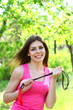 Girl posing with a skipping rope on the background of trees