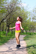 Young woman jumping with a skipping rope in a summer park