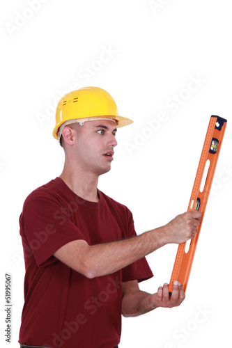Photo: A manual worker with a level. A manual worker with a level.