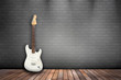 Raum mit Holzboden, Ziegelwand und E-Gitarre weiß