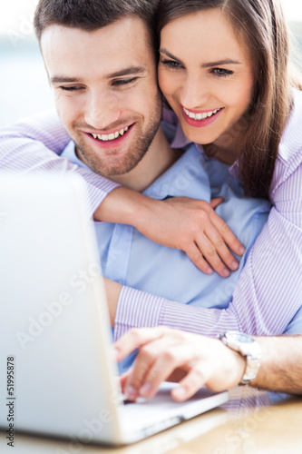 Photo: Young couple using laptop Young couple using laptop