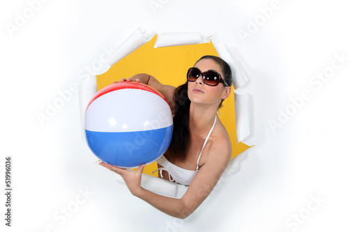 Photo: Woman with beach ball coming out of hole Woman with beach ball coming out of hole