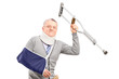 A happy mature gentleman with broken arm holding a crutch
