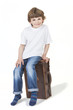 Young Happy Boy Smiling Sitting on Suitcase