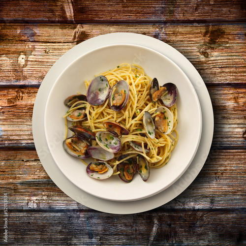 Photo: spaghetti alle vongole su fondo di legno spaghetti alle vongole su fondo di legno