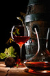 Foto: A glass of red wine next to a decanter A glass of red wine next to a decanter