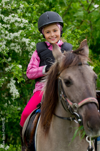 Photo: Horse riding - lovely girl is riding on a horse Horse riding - lovely girl is riding on a horse