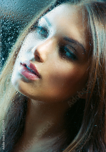 Photo: Portrait of Beauty Girl behind the Wet Glass Portrait of Beauty Girl behind the Wet Glass