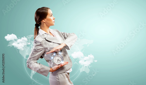 Photo: Businesswoman holding alarmclock Businesswoman holding alarmclock