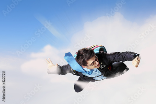 Photo: Young businessman flying with parachute on back Young businessman flying with parachute on back