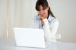 Pensive young female reading on laptop screen