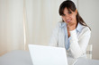 Charming young woman looking at you using laptop