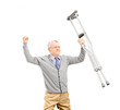 A happy gentleman patient holding crutches and gesturing happine