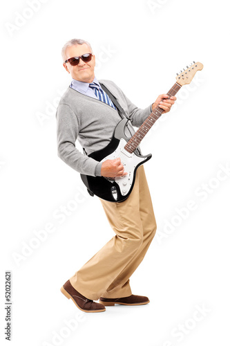 Photo: Full length portrait of a smiling mature man playing guitar Full length portrait of a smiling mature man playing guitar