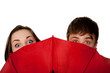 Teenagers, a boy and a girl, peeping for the red umbrella.