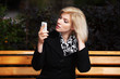 Young blond woman looking at mobile phone