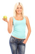 A studio shot of a blond smiling woman holding a green apple and