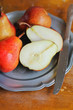 Fresh ripe pears in a plate with napkin and knife