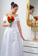 Beautiful bride in wedding dress holding bouquet of roses