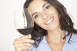 Südländische Frau lächelt mit Glas Rotwein