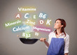 Young woman cooking vitamins and minerals