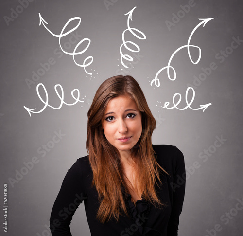 Photo: Young woman thinking with arrows overhead Young woman thinking with arrows overhead