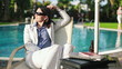 Happy businesswoman relaxing by the swimming pool