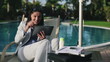 Successful businesswoman with tablet computer by the pool