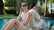Businesswomen talking on cellphone by the swimming pool