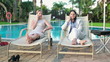 Businesswomen talking on cellphone by the swimming pool