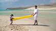 Father and son with air mattress on the beach