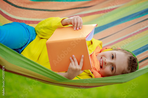 Photo: Young girl in headphones reading a book Young girl in headphones reading a book