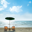 Beach chairs and umbrella on beach.
