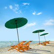 Beach chairs and umbrella on beach.