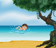 A boy swimming at the beach with an old tree